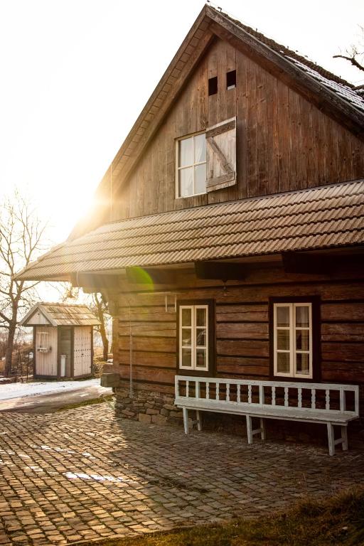 a wooden house with a bench in front of it at Cifrovaná drevenička in Detva