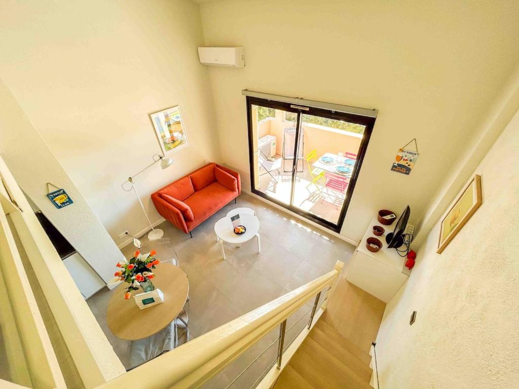 un salon avec un canapé rouge et une table dans l'établissement T2 - Piscine - Parking - Plage, à Six-Fours-les-Plages