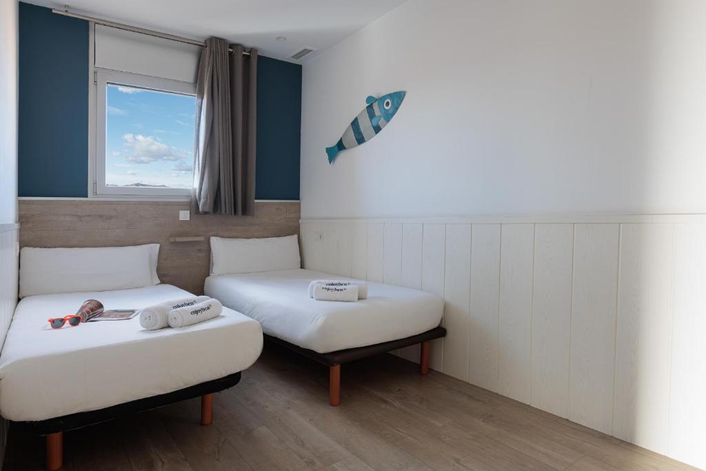A bed or beds in a room at Enjoybcn Marina Apartment