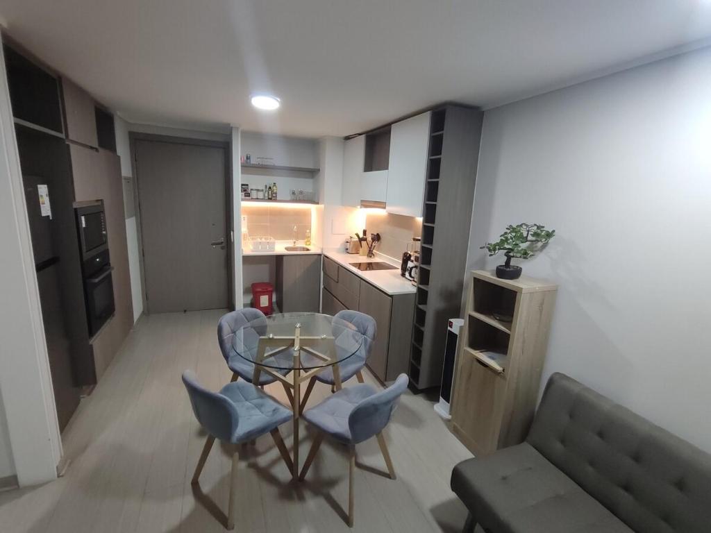a living room with a table and chairs and a kitchen at Comodidad y tranquilidad en Ñuñoa in Santiago