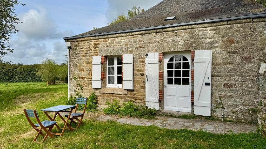 a stone house with two chairs and a table at Gîte de couple Cosy avec vue sur Château Trémohar - Golfe du Morbihan, 20 min de Vannes in Berric