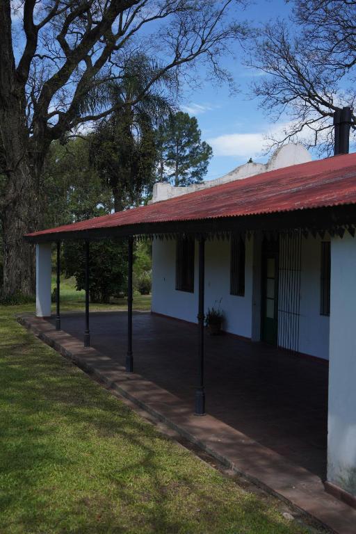 a white building with a red roof and grass at Quinta San Miguel in Concordia