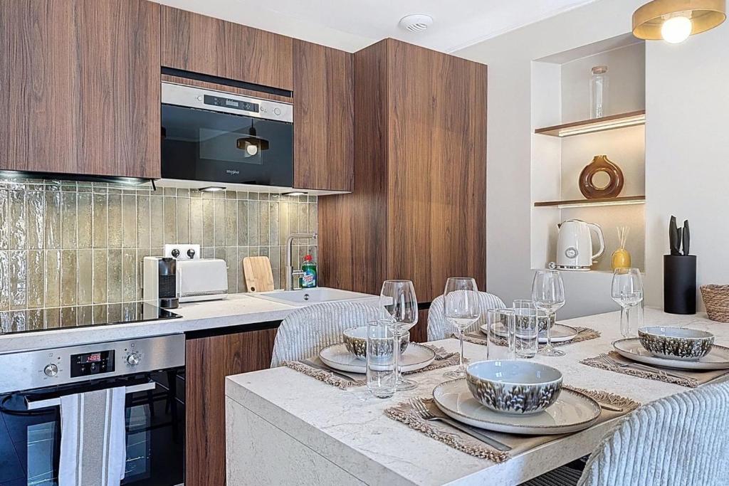 une cuisine avec une table avec des verres à vin dessus dans l'établissement Le Montfleury 2 pièces à 300m de la plage, à Cannes