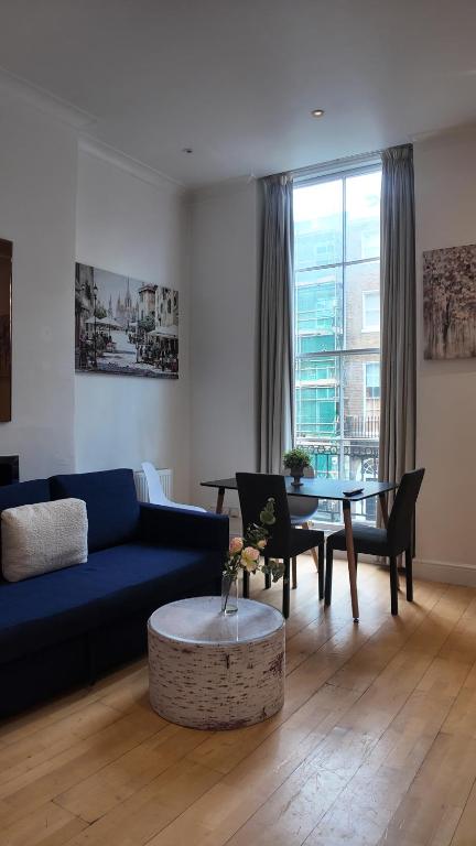 a living room with a blue couch and a table at Cozy Apartment Sleep 5 in Berkely BK3 in London