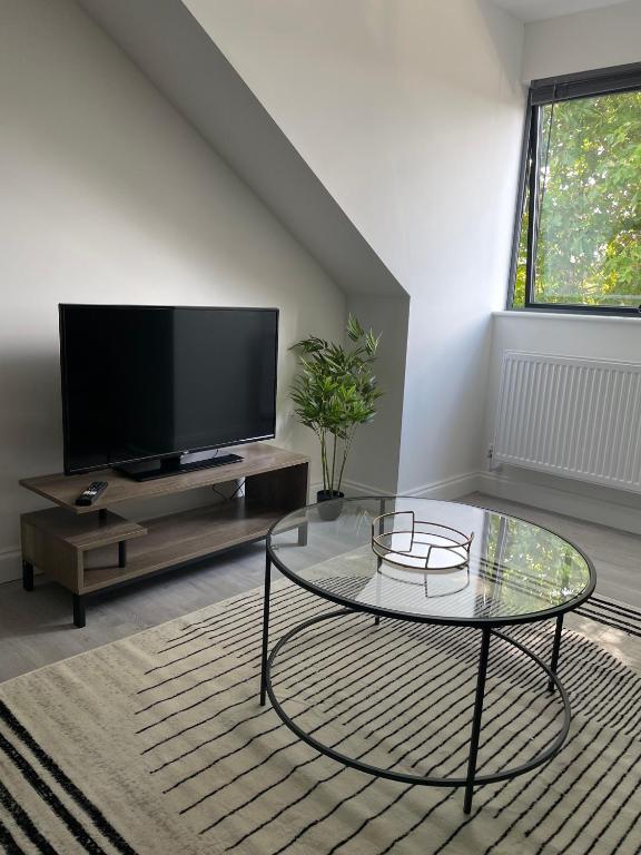 a living room with a tv and a glass coffee table at Royal Oak 7 - FREE PARKING - Sleeps 5 - Perfect for Contractors - Near Shops - Wi-Fi - Long Term Stays in Brentwood
