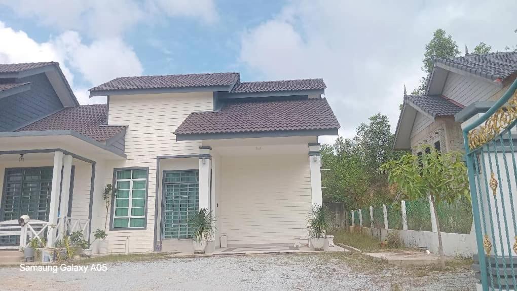 una casa blanca con una valla delante en Homestay Al Ayyubi Medan Jaya, en Marang