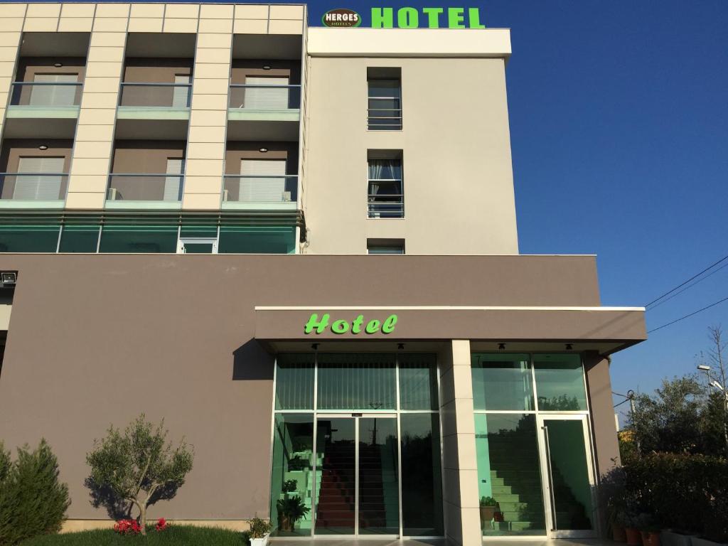 um edifício de hotel com uma placa de hotel em Herges Hotel em Durrës