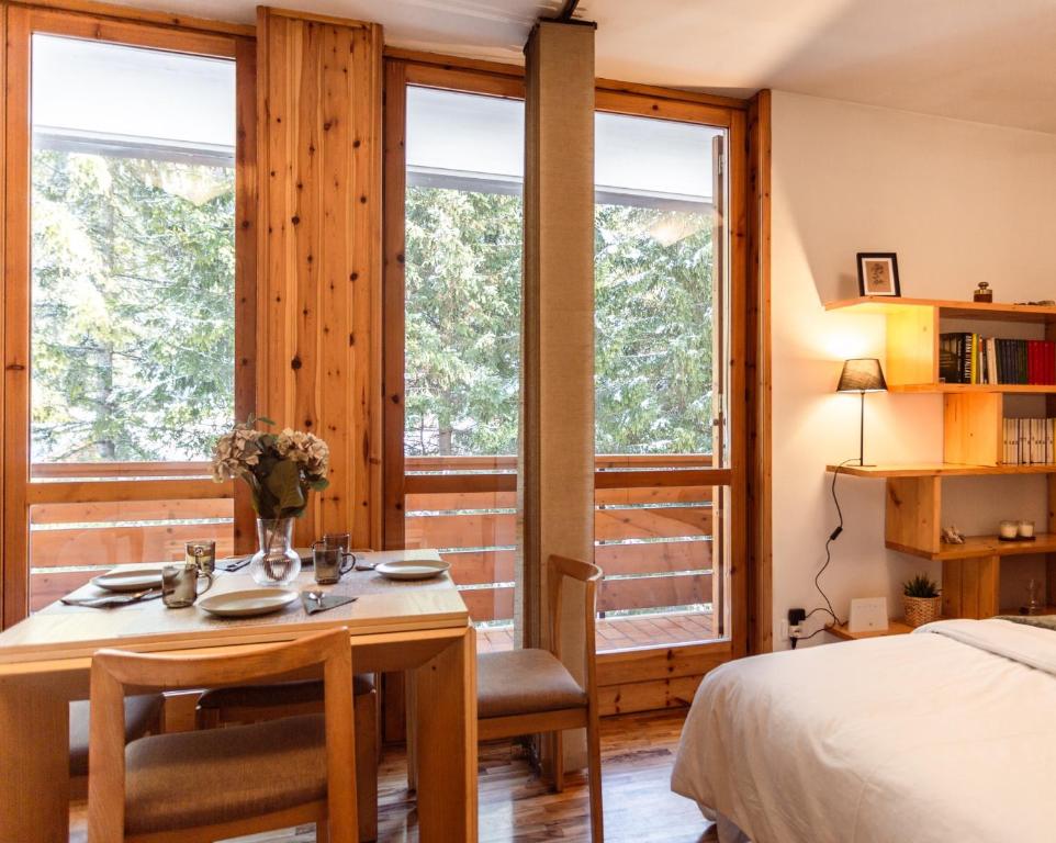 una camera da letto con un letto, un tavolo e delle sedie di [* * *Premium Loft* * *] vista Marmolada ad Alba di Canazei