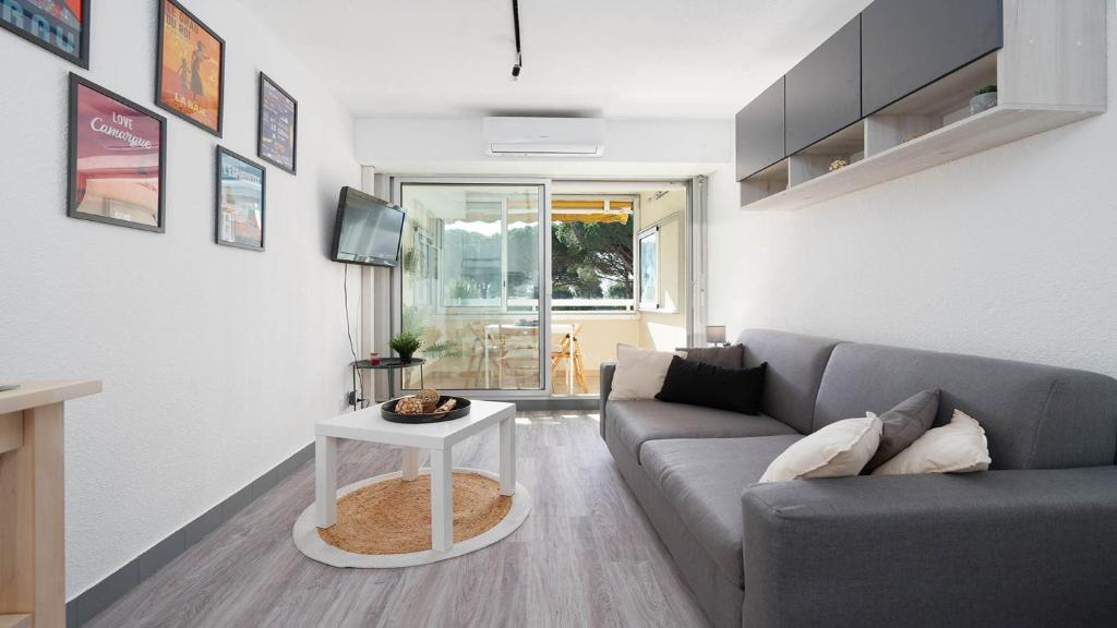 un salon avec un canapé et une table dans l'établissement LA LAGUNE -105- Studio cabine 4 pers, au Grau-du-Roi