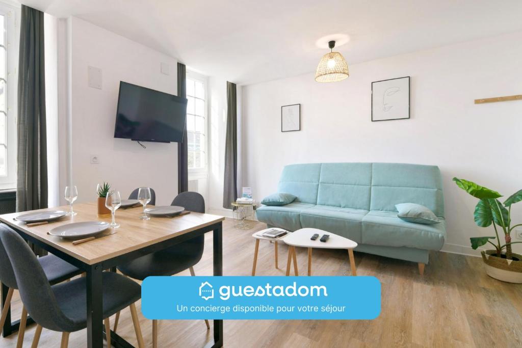 un salon avec un canapé bleu et une table dans l'établissement La Casa Wifi 500m centre-ville, à Laval