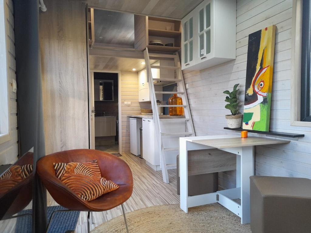 a small kitchen with a white table and a desk at Tiny House Egmond in Egmond aan den Hoef