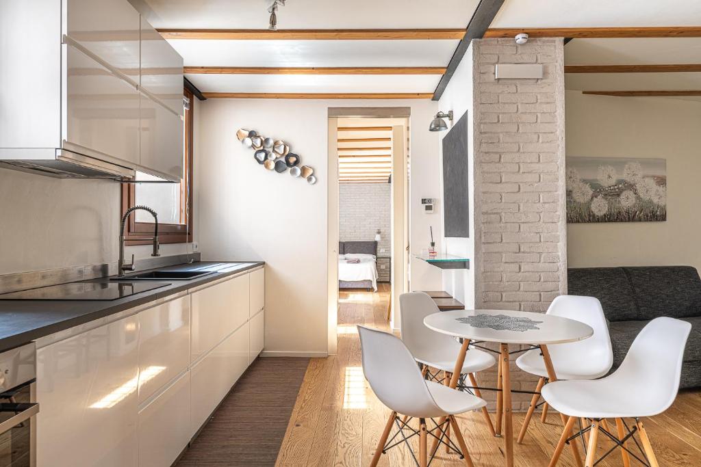 ヴィチェンツァにあるBasilica Prestige Residence, lusso e comfortのテーブルと椅子のあるキッチンとダイニングルーム