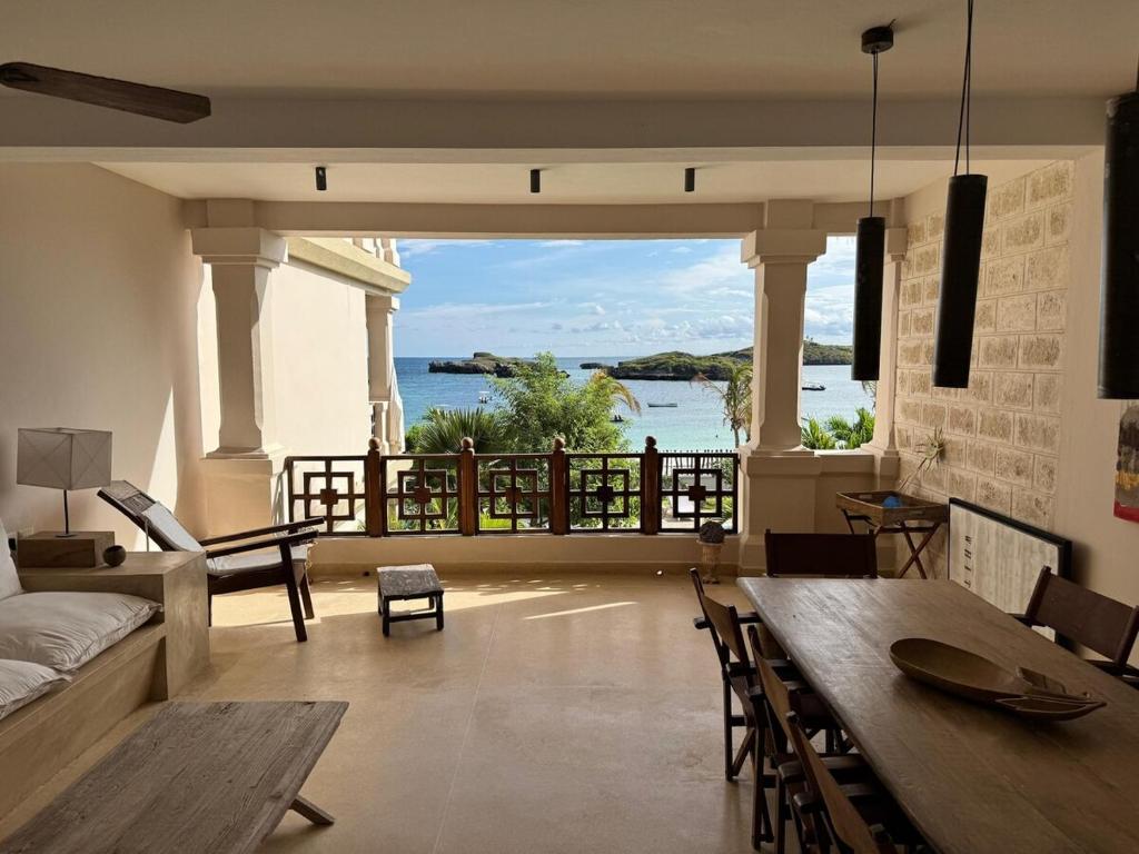 a living room with a table and a view of the water at Casa Sanaa - Sea view in Watamu