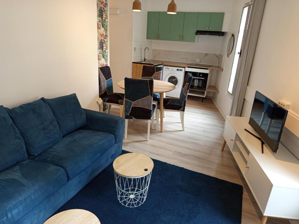 un salon avec un canapé bleu et une table dans l'établissement Calme, confortable et bien placé, à Nice