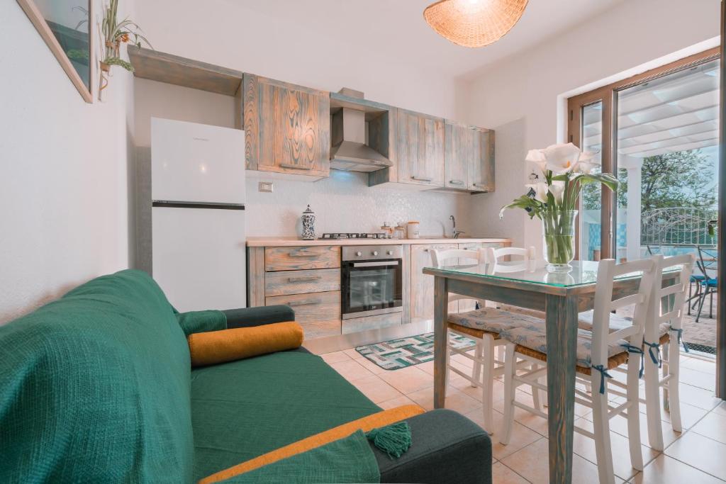 un salon avec un canapé vert et une table dans l'établissement Giobo Mare, à La Caletta