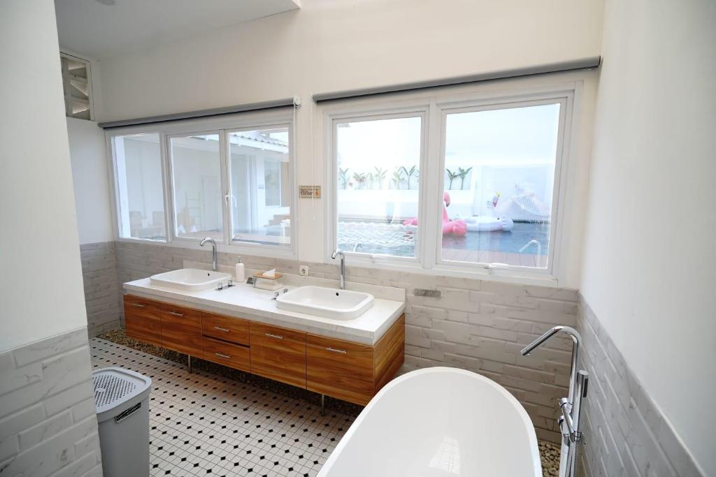 baño con aseo y lavabo y 2 ventanas en Kala Cabin Cinema, en Bongkor 1