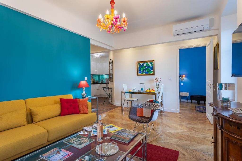 un salon avec un canapé jaune et un mur bleu dans l'établissement LE ROYAL AP4456 by Riviera Holiday Homes, à Nice