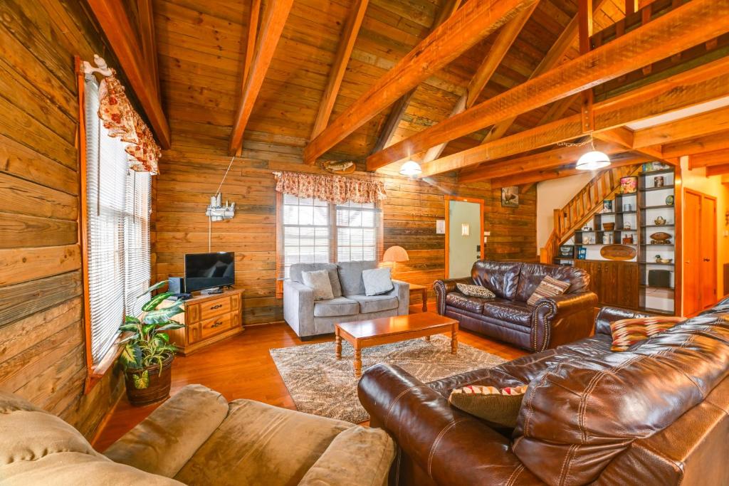 a living room with leather furniture in a log cabin at Game Room and Decks Family Cabin in Springville! in Springville