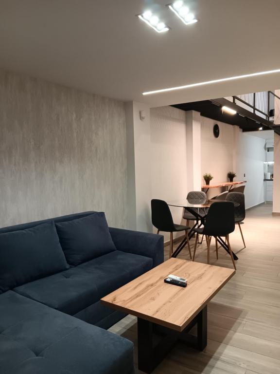 a living room with a blue couch and a table at Loft of e-smile in Thessaloniki