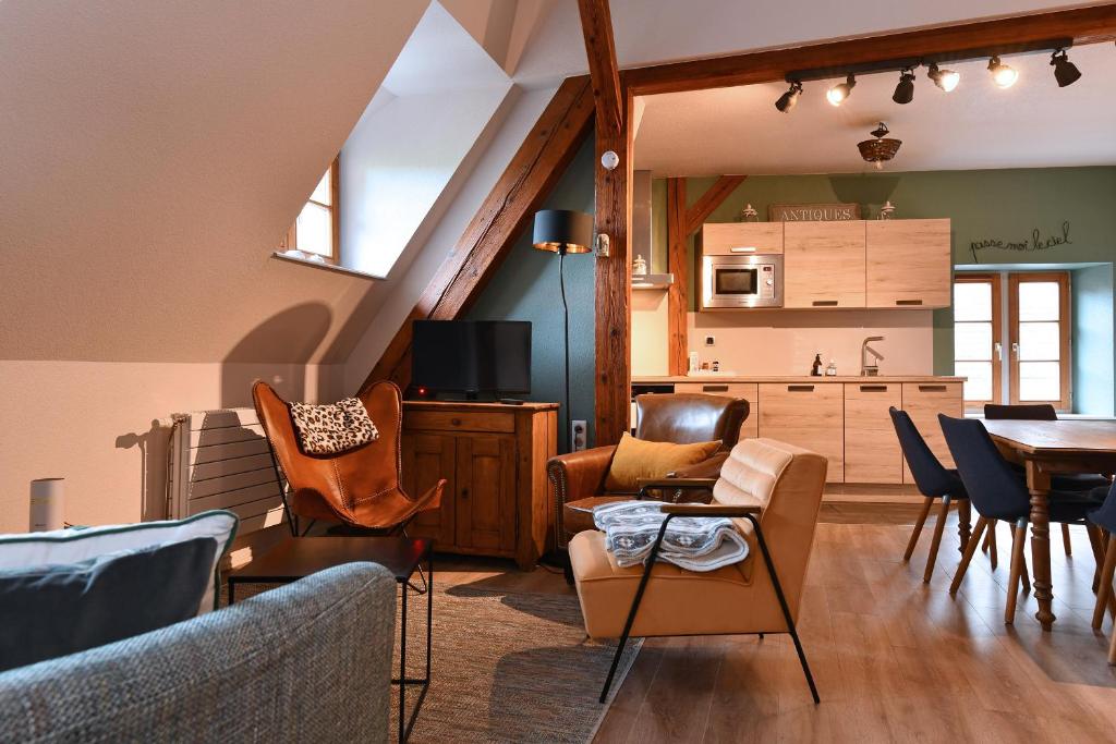 a living room with a table and chairs and a kitchen at Appartement Beraweka avec Parking, Climatisation et Salle de Sport in Colmar