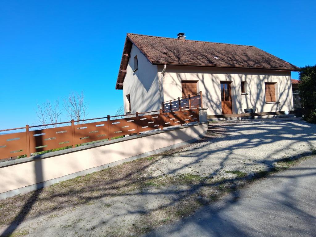 un bâtiment blanc avec une clôture à côté d'une route dans l'établissement les sables, à La Celle-sous-Gouzon