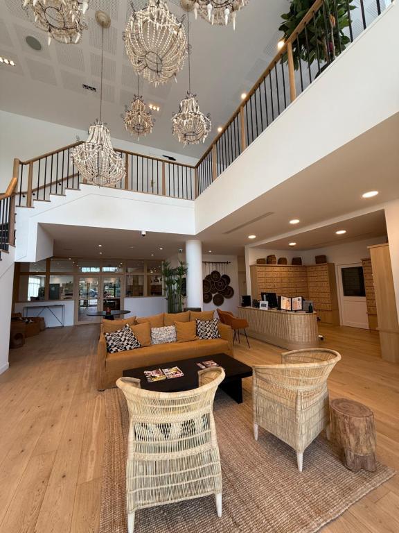 una sala de estar con un sofá y sillas en Résidence Montana Reims Tinqueux, en Tinqueux