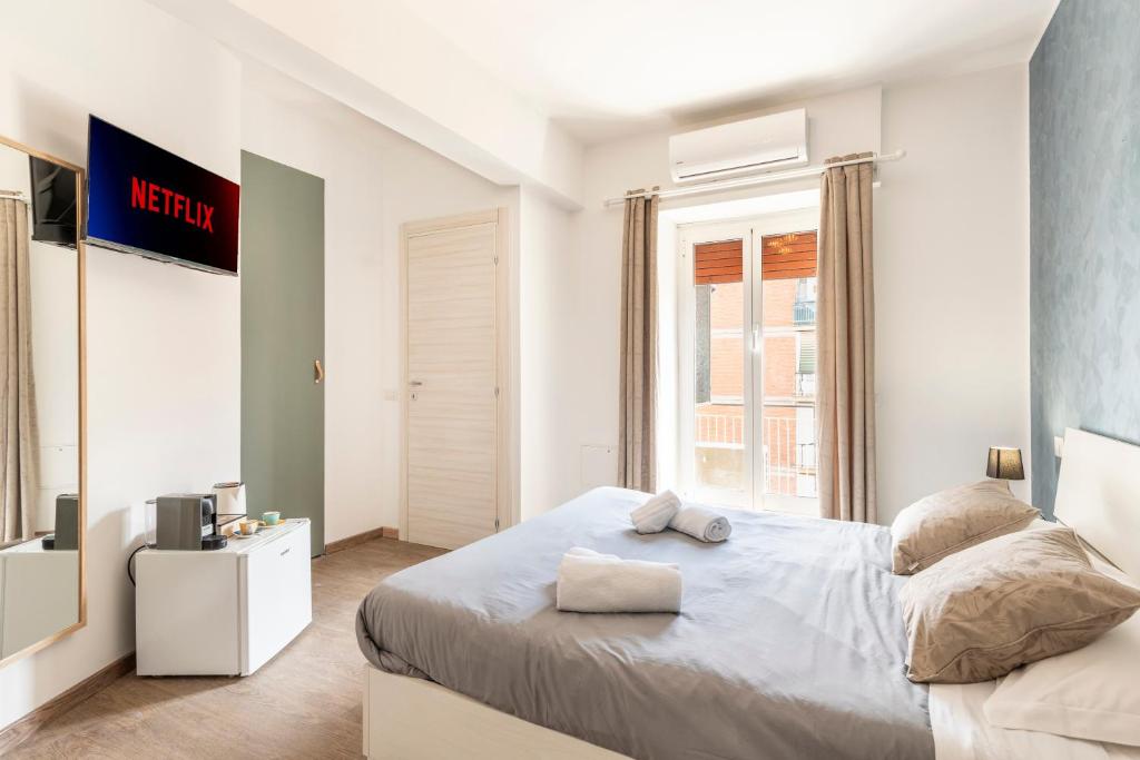a white bedroom with a large bed and a tv at Bnb Drive In in Rome