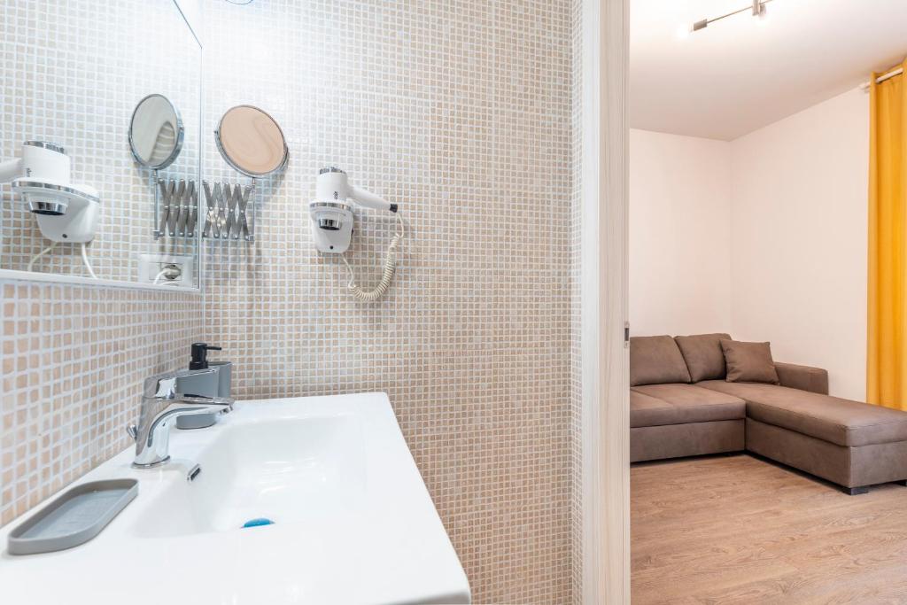 a bathroom with a white sink and a couch at Bnb Drive In in Rome