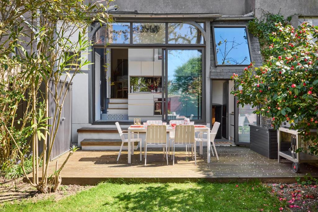 - une table et des chaises dans le jardin d'une maison dans l'établissement Le Jardin Secret - 2 chambres & Parking Offert, à Nantes