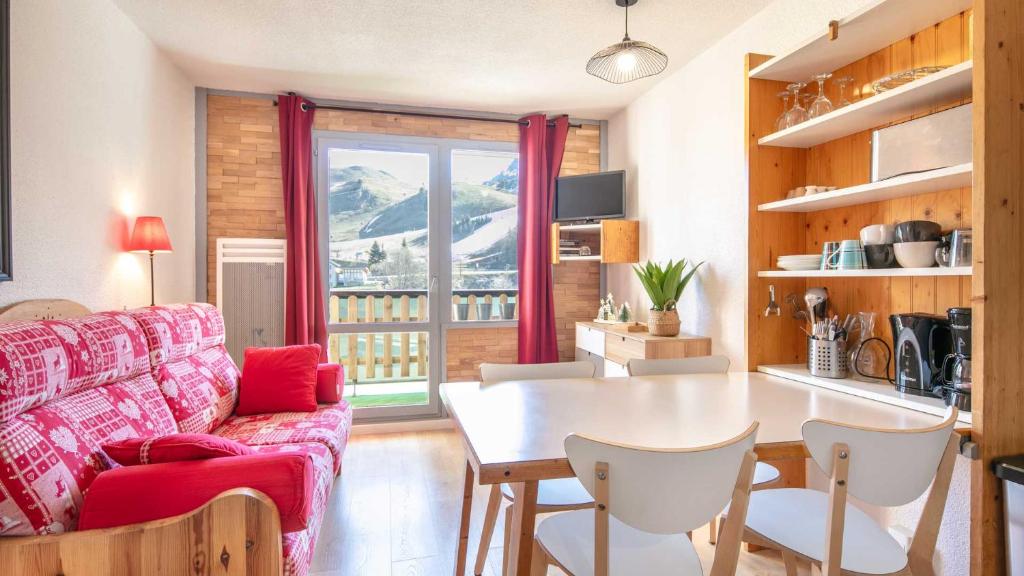 un salon avec un canapé rouge et une table dans l'établissement Le Vernon N1021 - ST4, à Chamrousse
