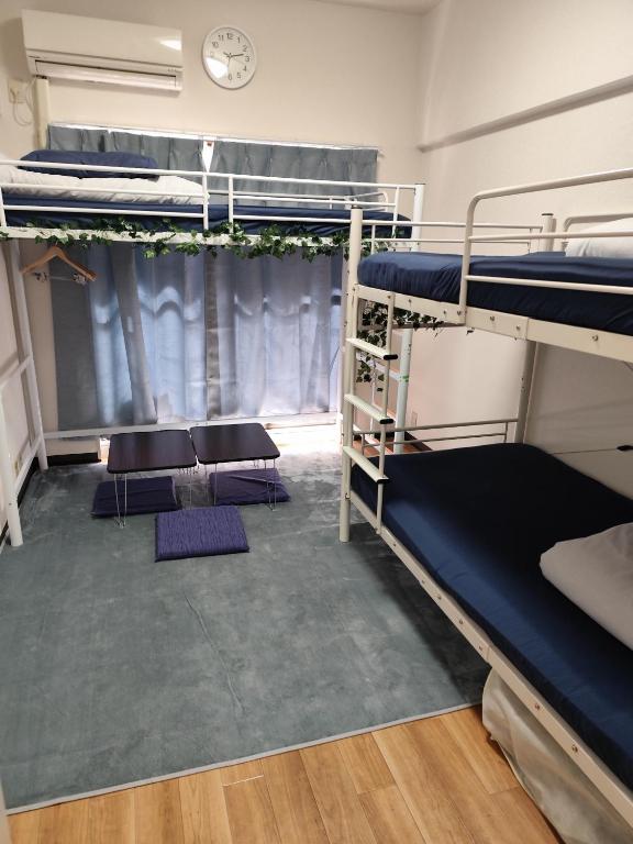 a room with two bunk beds and a clock at JKhouse4 in Fukuoka
