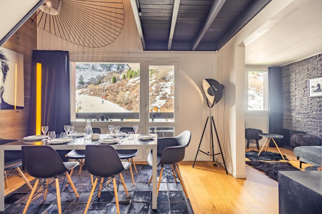 une salle à manger avec une table et des chaises dans l'établissement Ski-in Ski-out 3-Bedroom Duplex Méribel Mottaret, à Méribel