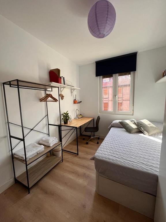 Un dormitorio con una cama y un escritorio. en Habitación cerca del centro, baño y cocina compartida, en Bilbao
