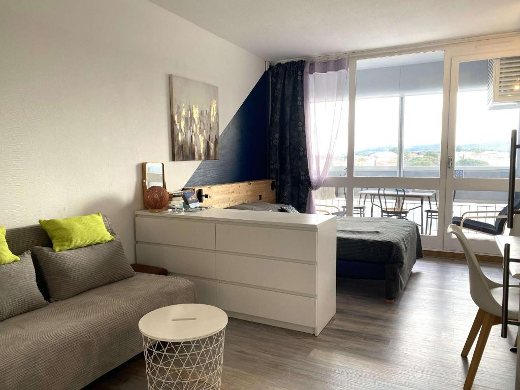 un salon avec un lit et un canapé dans l'établissement Confortable studio avec loggia fermée, 29m², wifi - FR-1-553-260, à Balaruc-les-Bains