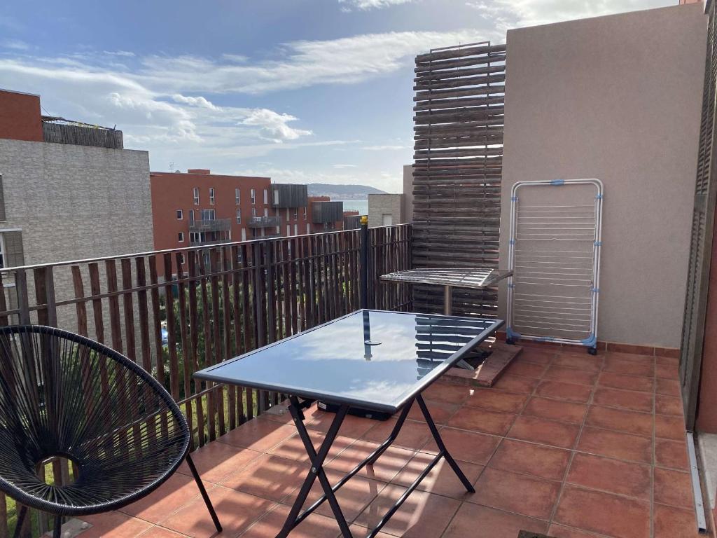 un patio avec une table et des chaises sur un balcon dans l'établissement Bel Appartement T2 avec Terrasse et Garage à Balaruc-les-Bains - FR-1-553-269, à Balaruc-les-Bains