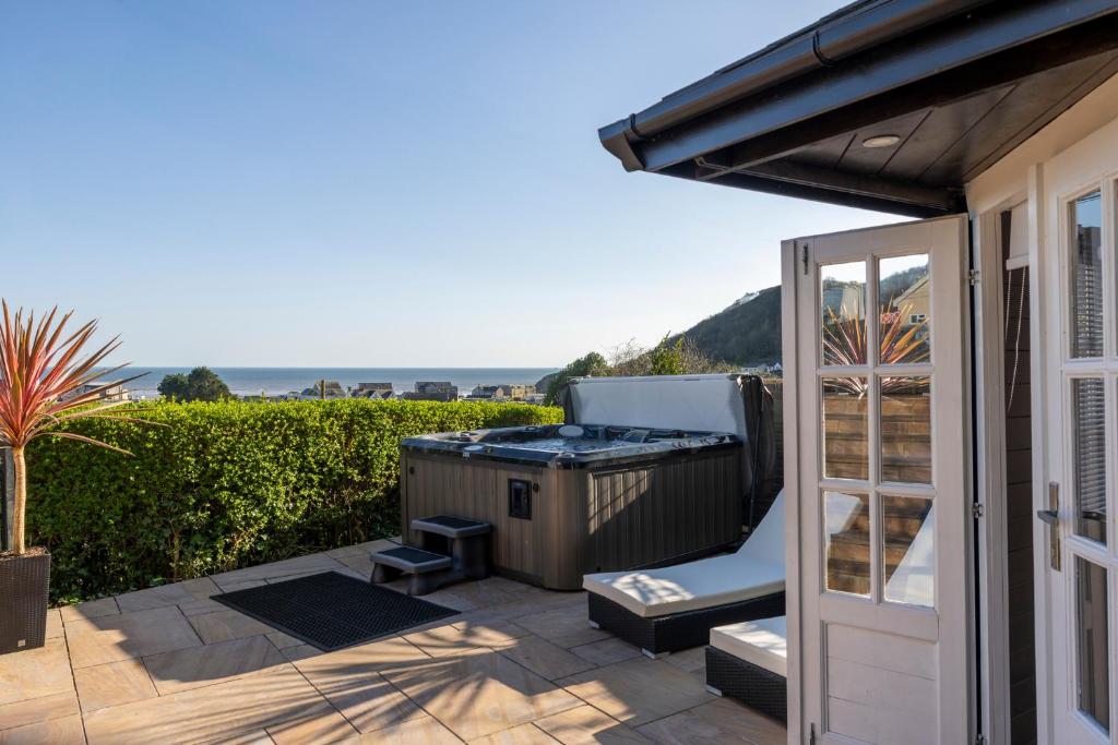 a barbecue on a patio with a view of the ocean at Pendine Sands Edith Villas - a luxury seaside home with beautiful sea views in Pendine