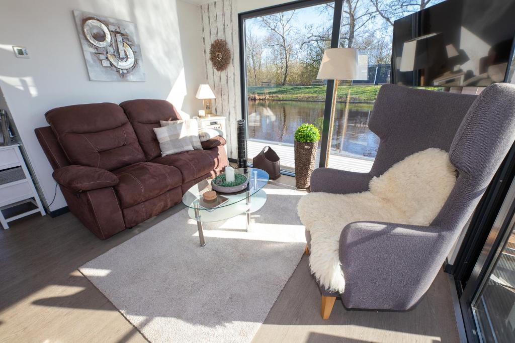 a living room with a couch and a chair and a table at Hausboot "Seelounge" in Bad Bederkesa