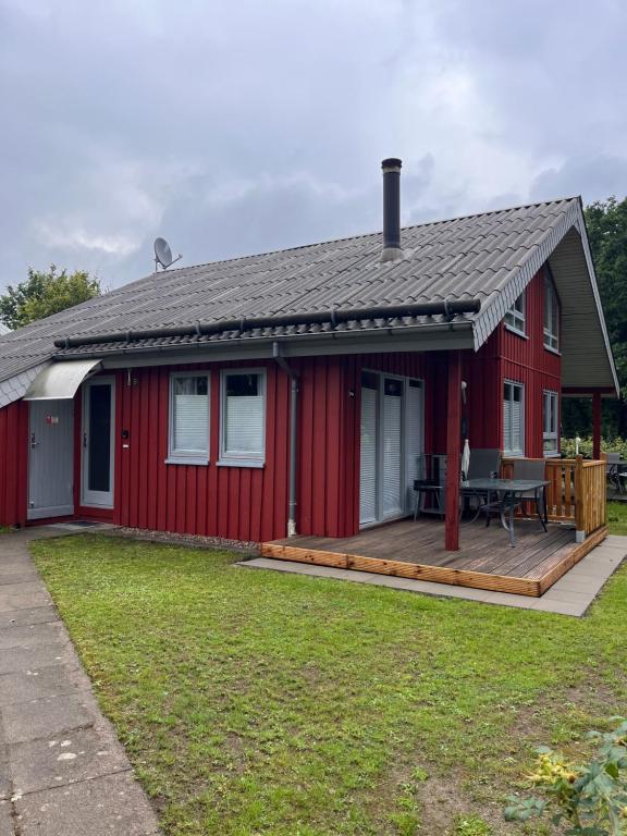 a red house with a deck and a table at Ferienhaus Vita in Extertal