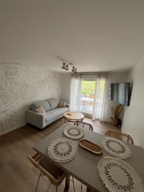 un salon avec une table, des chaises et un canapé dans l'établissement La Bali house, à Voiron