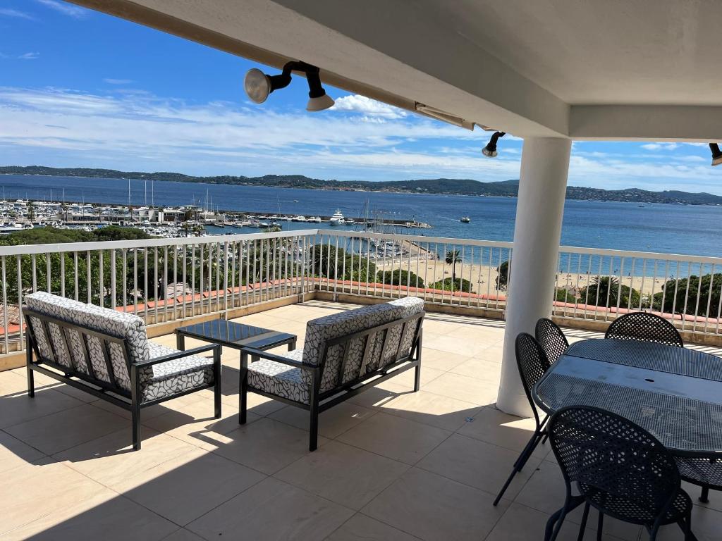 d'un balcon avec une table et des chaises et une vue sur l'eau. dans l'établissement Palais du soleil, à La Celle-sous-Gouzon