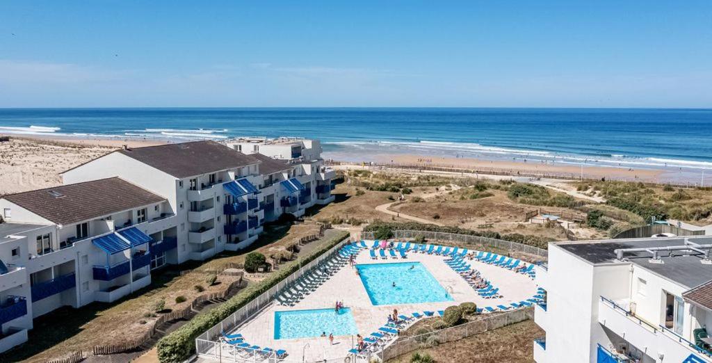 - une vue aérienne sur une piscine à côté de la plage dans l'établissement T2 Bord de plage, résidence Bleu Marine 85, à Lacanau-Océan