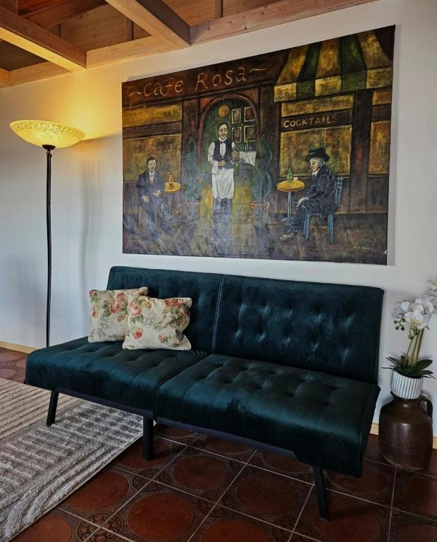 a green couch in a living room with a painting at FeWo Italien in Neue Scheune