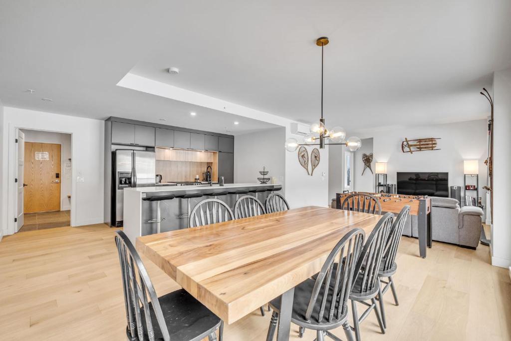 una cucina e una sala da pranzo con tavolo e sedie in legno di Initial - the chalet - MSA SKI IN and OUT a Beaupré