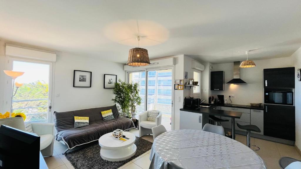 un salon avec un canapé et une table dans l'établissement Immersion marine, T2 front de mer, à Saint-Hilaire-de-Riez