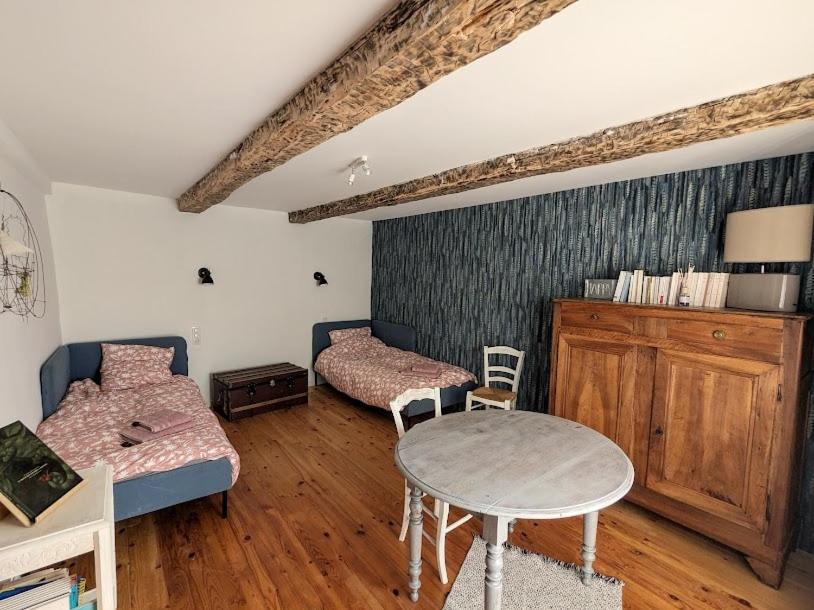 a room with two beds and a table in it at Renovated Charming Farm with Activities Around in Lagrand