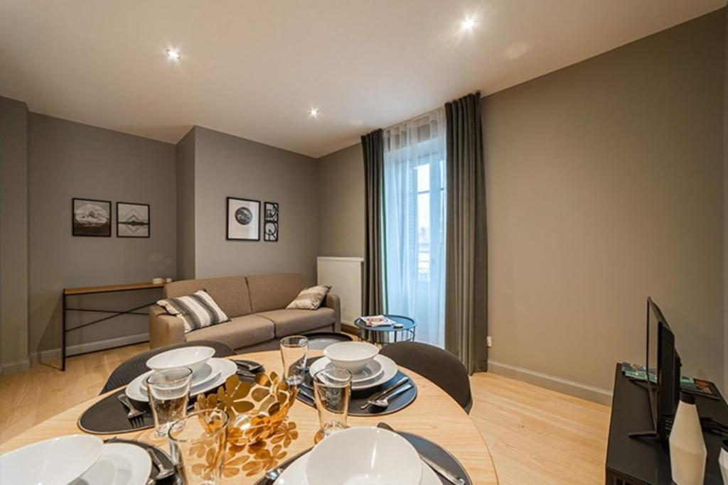 un salon avec une table et un canapé dans l'établissement Appart standing Belval plein centre 4 parking, à Aix-les-Bains