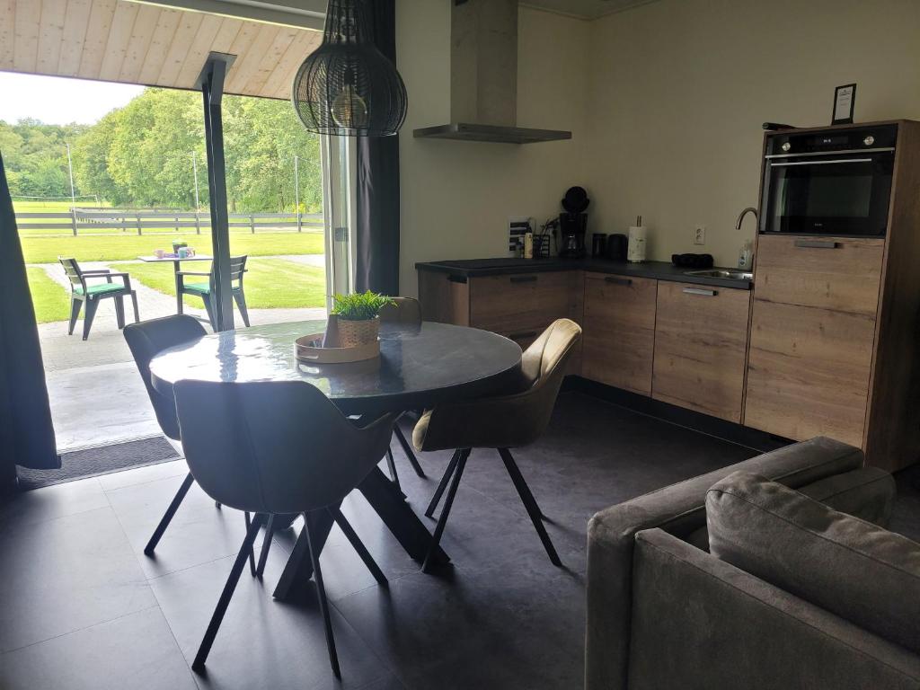 a kitchen and dining room with a table and chairs at Timmershoeve in Vorstenbosch