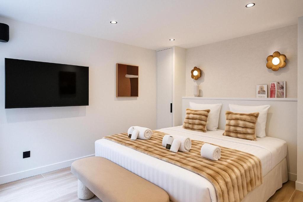 une chambre avec deux lits et une télévision à écran plat dans l'établissement Chic Studio Charonne, Haut-Marais, à Paris