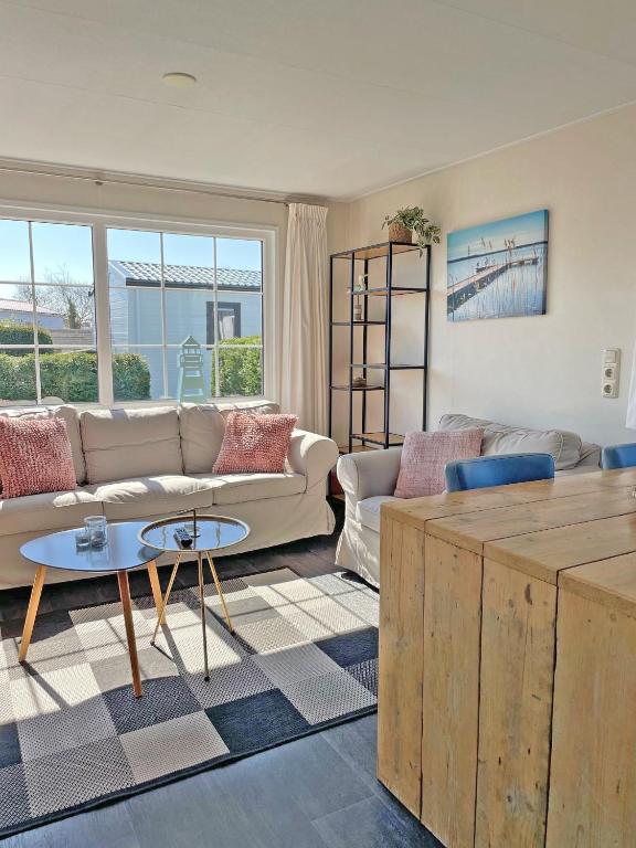 a living room with a couch and a table at Chalet Zilt Ameland in Hollum
