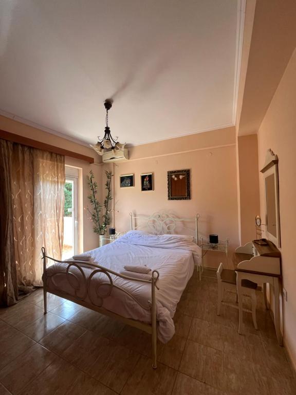 een slaapkamer met een bed, een bureau en een raam bij Angellinas Apartments in Kato Daratso